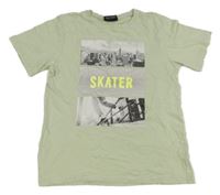 Světleolivové tričko se skateboardistou a budovami beatwear