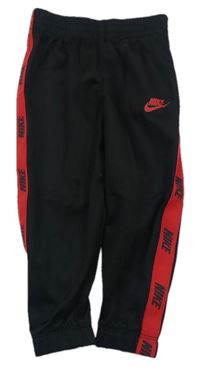 Černé sportovní tepláky s červenými pruhy a logem Nike 