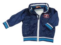 Tmavomodrá šusťáková jarní bunda s nášivkou a ukrývací kapucí 