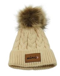 Pudrová vzorovaná pletená čepice s nášivkou a bambulí