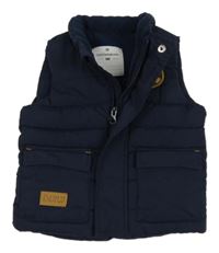 Tmavomodrá šusťáková zateplená vesta s nášivkou