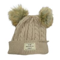 Béžová čepice s nášivkou a bambulemi 