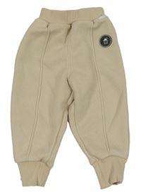 Béžové tepláky s puky a domečkem