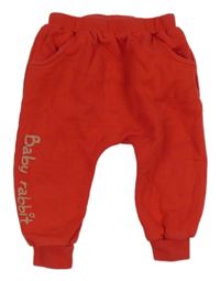 Červené tepláky s nápisem a čumákem 