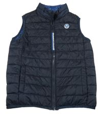 Tmavomodrá šusťáková zateplená vesta s nášivkou 