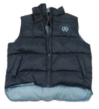 Tmavomodro-modrá prošívaná šusťáková zateplená vesta s nášivkou a nápisem